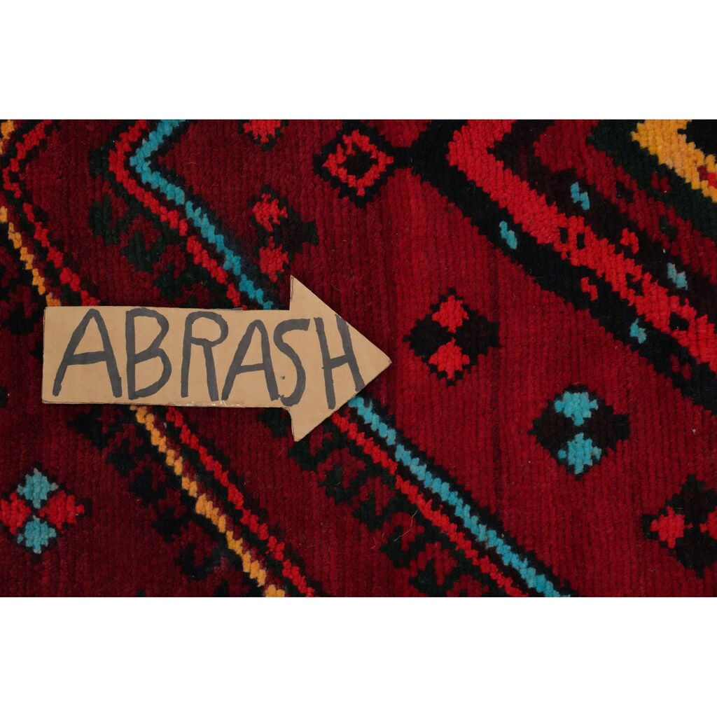 Cardboard arrow pointing right with the word ABRASH written in marker on a red geometric rug background.